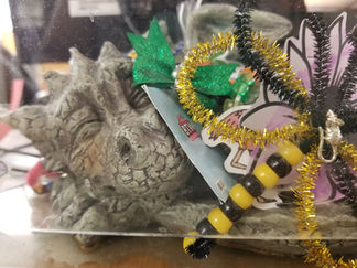 a stone dragon covered in drawings and colored images sitting on the circulation desk