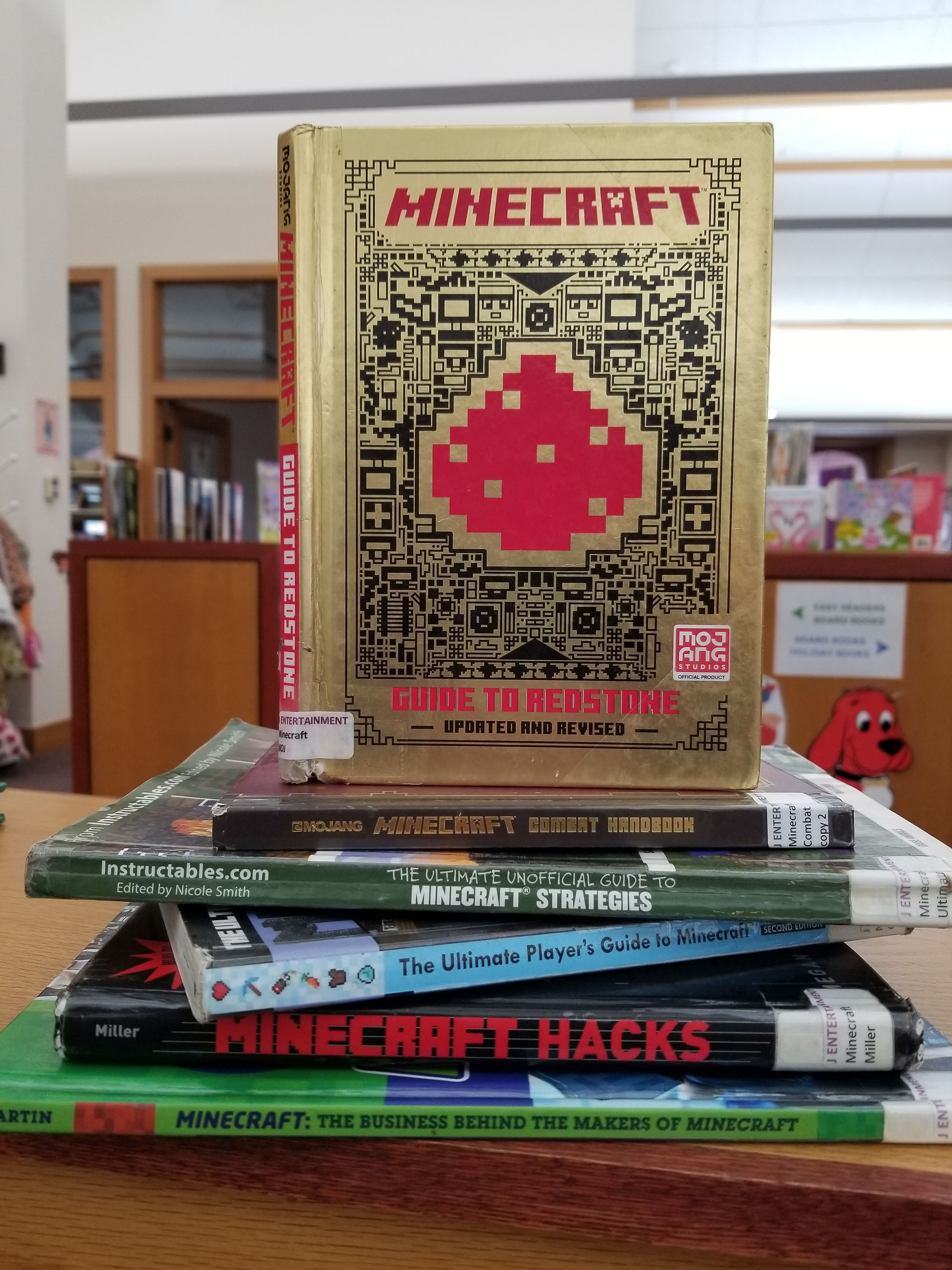 Selection of minecraft strategy books sitting on a wooden shelf