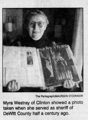 Newspaper clipping of Mrs. Myra Westray wearing glasses and smiling while holding her scrapbook