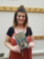 Photo of Callie holding the book Gregor the Overlander by Suzanne Collins