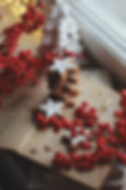 Photo of an open book, red berries and star gingerbread cookies