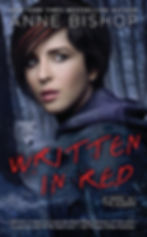 Book cover for Written In Red by Anne Bishop picturing a woman standing in a forest with a white wolf in the background.