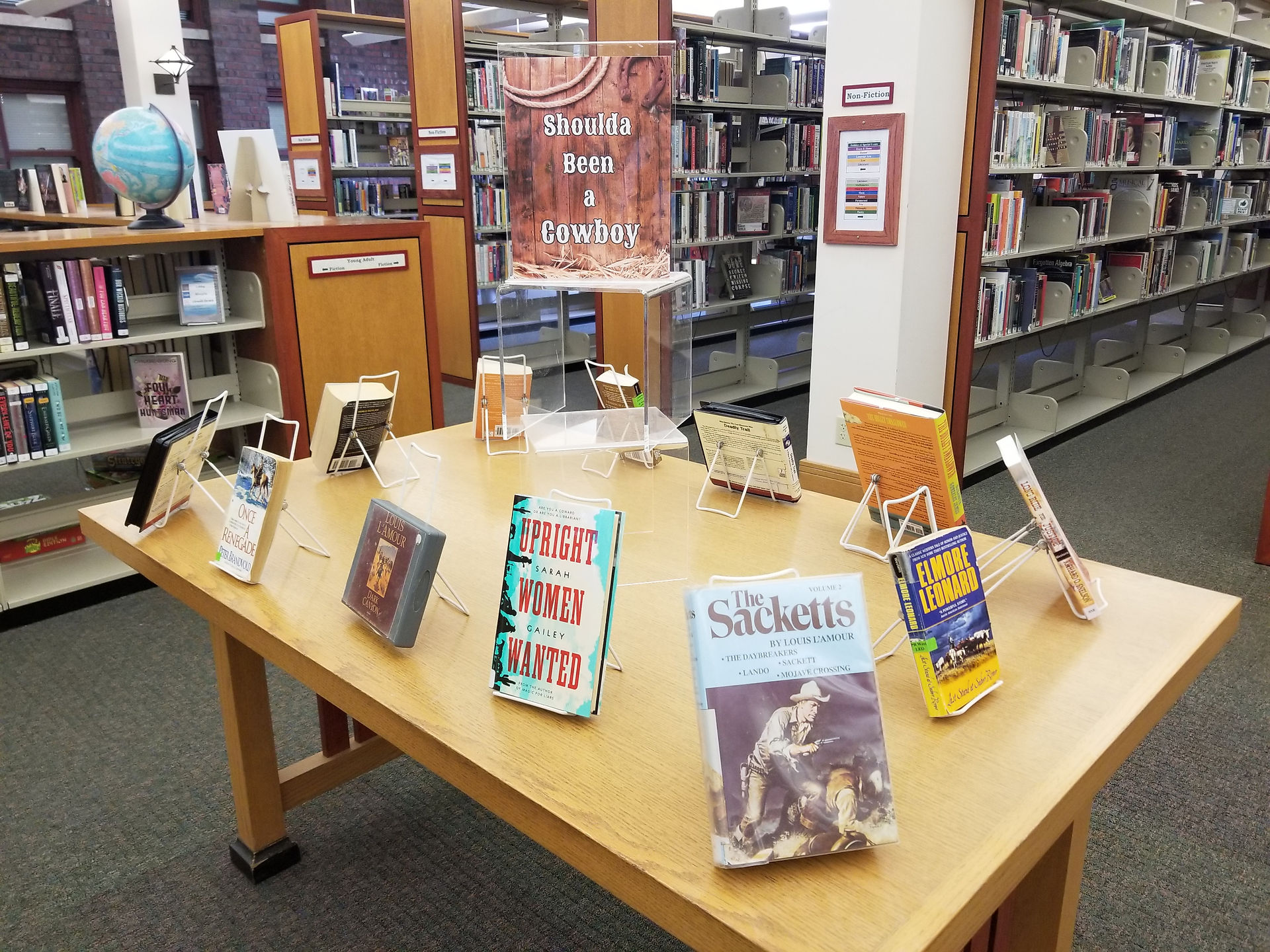 "Shoulda Been A Cowboy" display with an assortment of books and audiobooks.