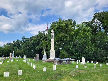 The Soldiers' Plot memorial surrounded by headstones and 2 cannons