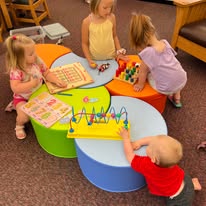 A group of children playing with different toys on the children's floor