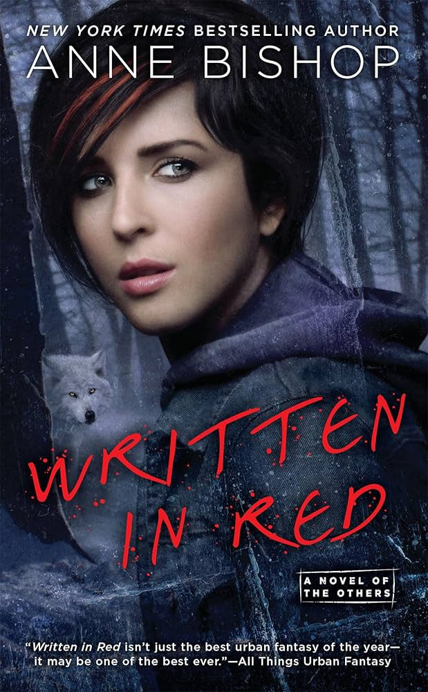 Woman with short dark hair in front of icy forest. Red text: "Written in Red" and quote at bottom. Mysterious and moody atmosphere.