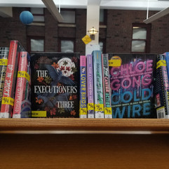 New Teen Fiction books on a wooden book shelf