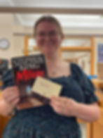 Photo of Olivia holding the book Misery by Stephen King