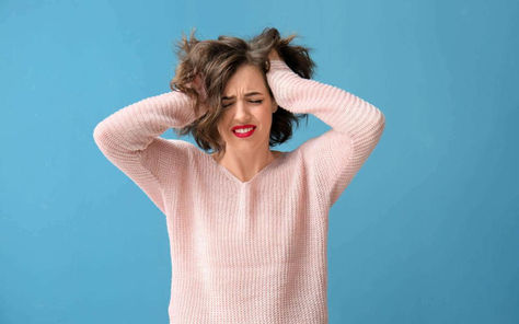 une femme qui se tient la tete car elle ne sait plus quoi faire