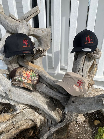 Four hats with RDI logos on driftwood