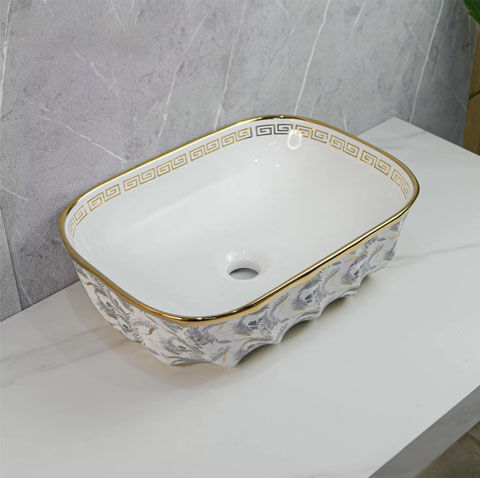 Weißes Waschbecken mit goldener Verzierung und floralem Muster