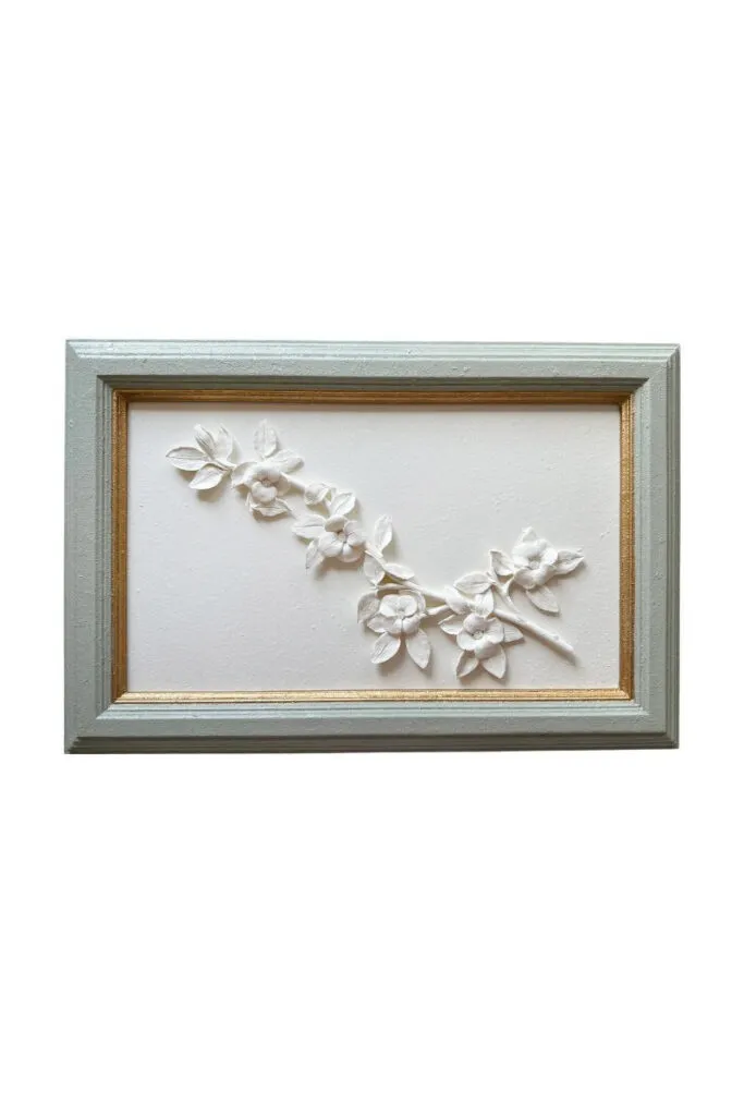 Framed plaster floral artwork featuring delicate botanical branches in soft neutral tones