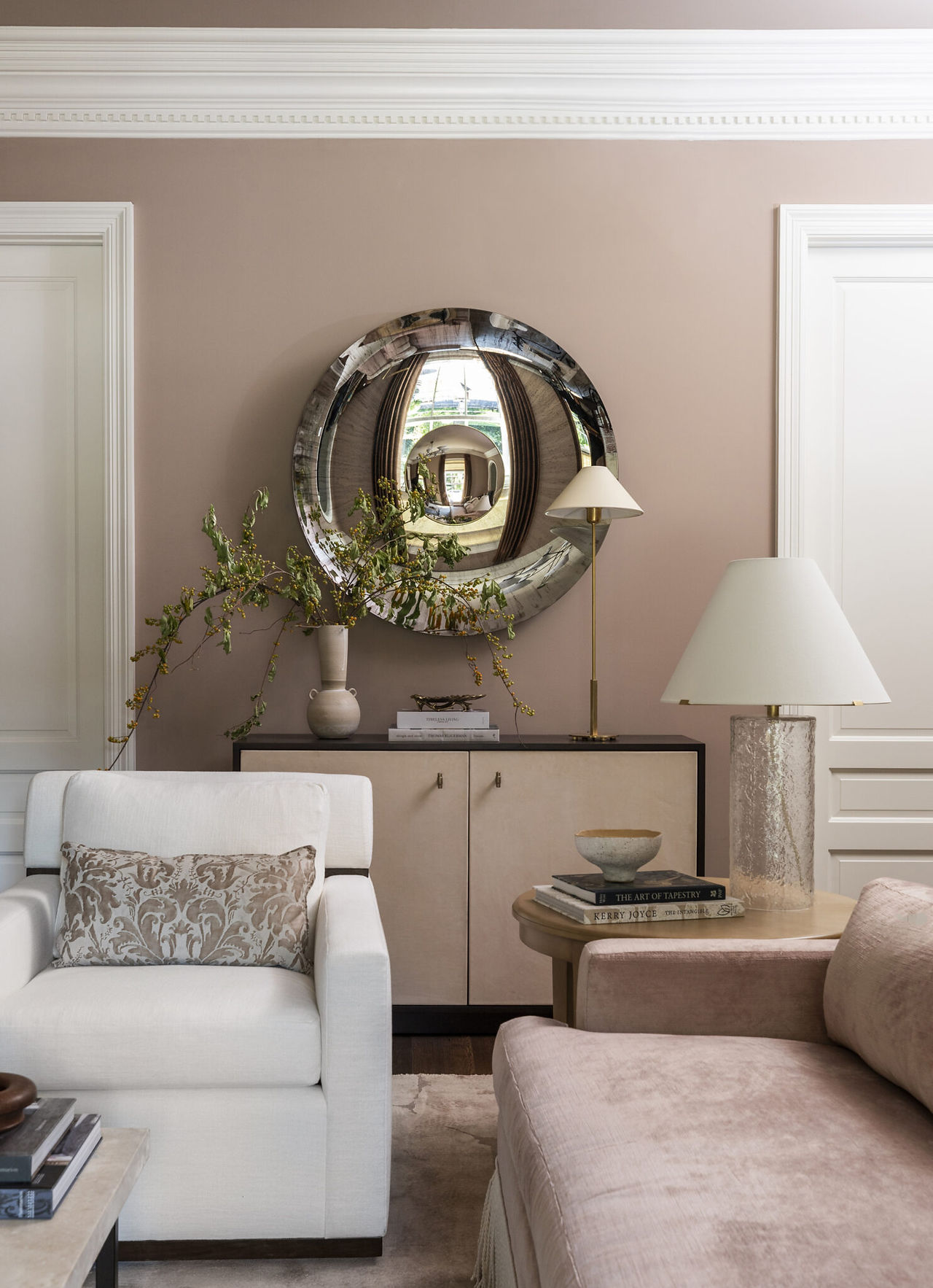 Formal living room with soft blush tones, layered seating, and timeless collected interiors