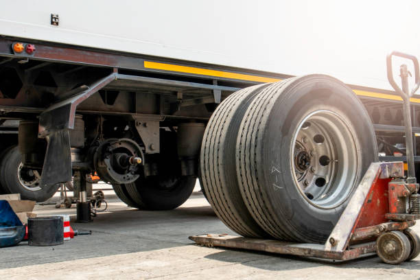 Trailer wheel removed for maintenance with a hydraulic jack in a repair area
