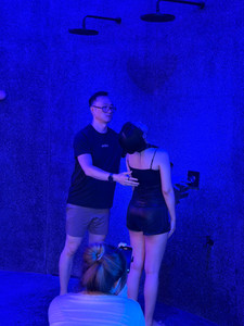 Revibe coach demonstrating the SejukSix 6°C cold shower experience during a wellness event.