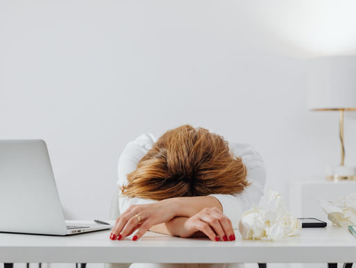 Woman resting face down at her office desk after a stressful workday