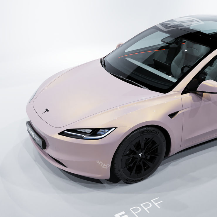 Close-up of a Tesla Model 3's front, wrapped in PurePPF Pearl Opal, highlighting the detailed luminous finish that shifts between pink, white, and peach hues, adding a unique and captivating appearance reminiscent of a precious opal gemstone.