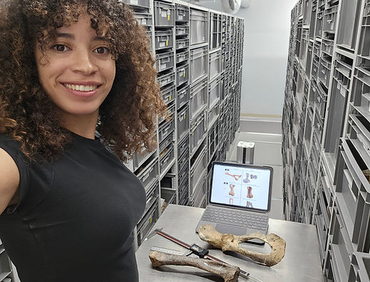 Selfie of Kiersten Formoso in museum collections. A seal pelvis, calipers, and an iPad screen are behind her.