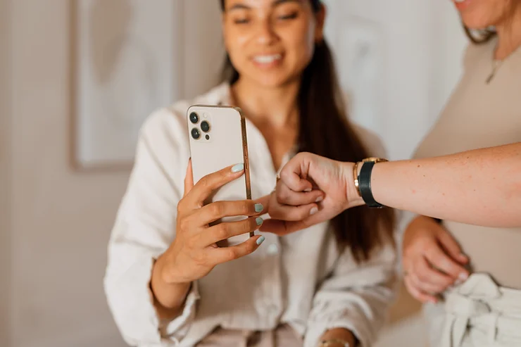 Gertrude van den Brink en collega bekijken de gemaakte interieurfoto's op telefoon