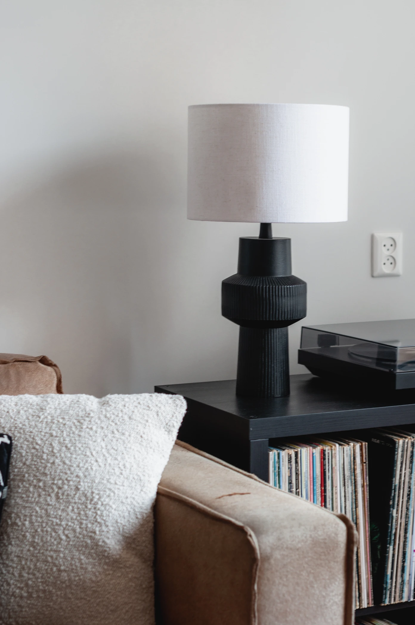 Interieurfoto's maken: beige bank naast zwarte kast met daarop een zwarte lamp met witte kap