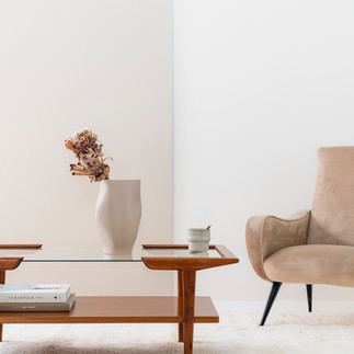 Interieurfoto's maken: houten tafel met vaas en beige fauteuil