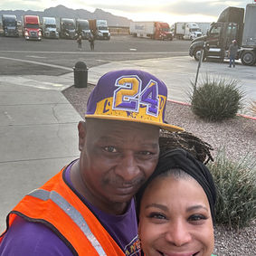 Walter and his wife, Vivian together near a fleet of semi trucks