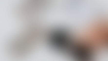 Hand using a smartphone calculator with US dollar bills and notebook for financial planning