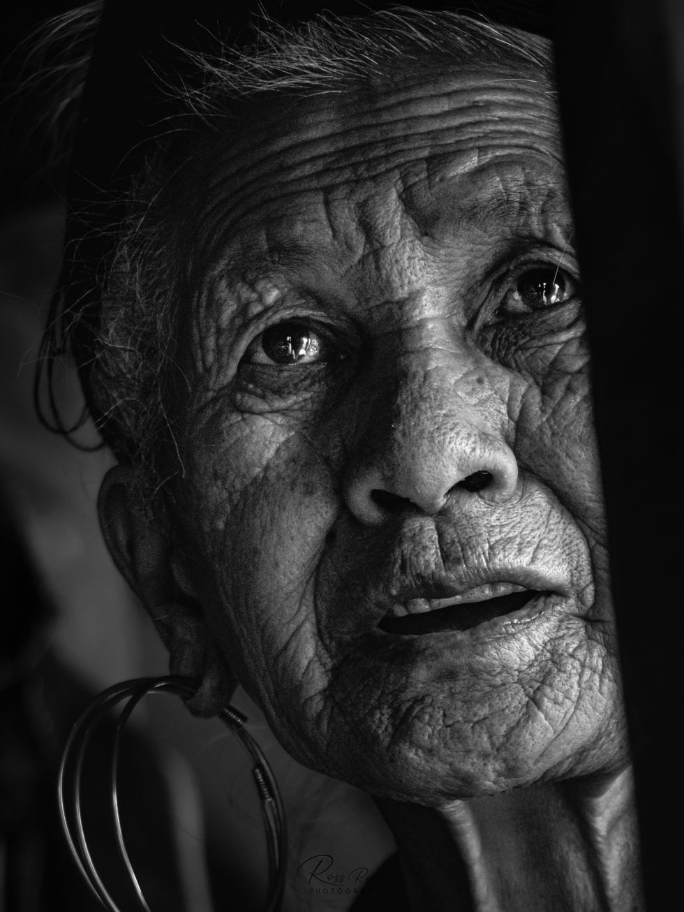 An old lady peers through he weaving machine at Cat Cat village in Sapa, Vietnam.