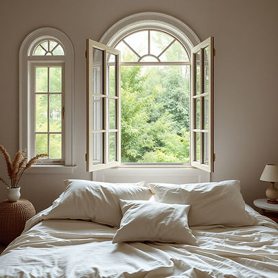 relaxing cozy retreat-style bedroom with open windows, greenery outside, soft linens, calm