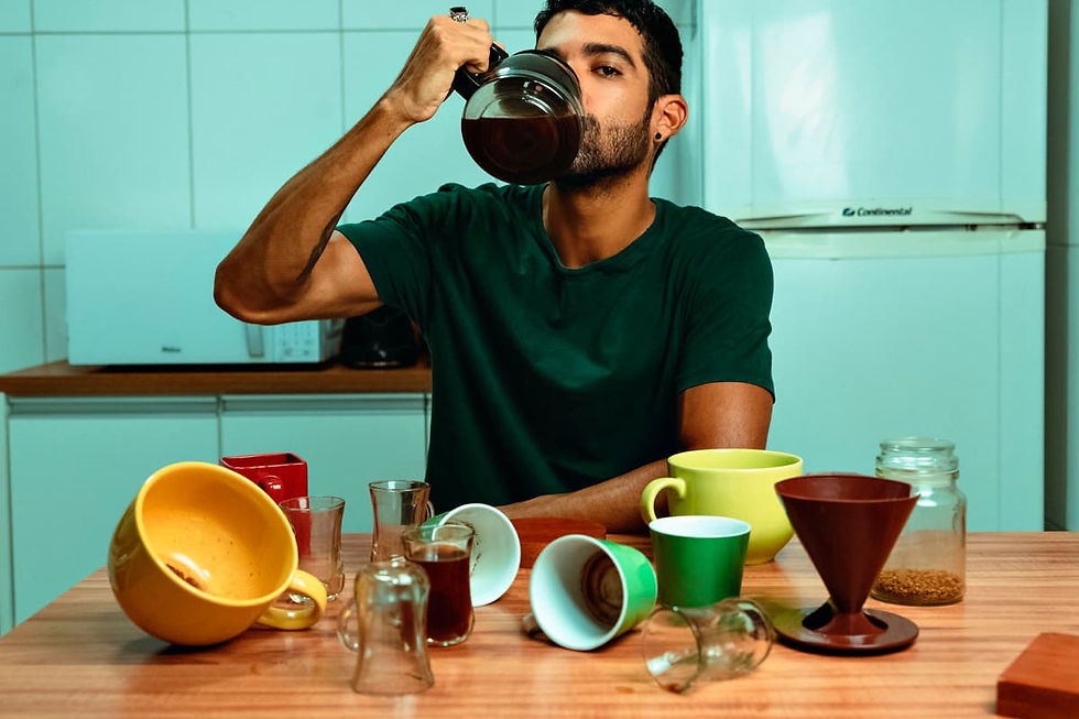 Hombre probando varias tazas de café de especialidad Café Kilapura sobre la mesa como parte de una cata.