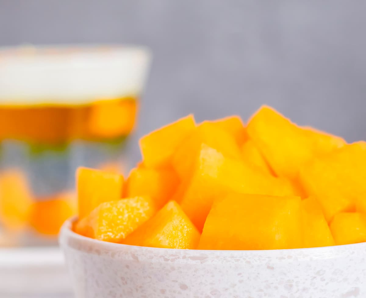 Trozos de mango fresco servidos en una taza blanca, representando las notas de sabor a mango que se perciben en el café de especialidad