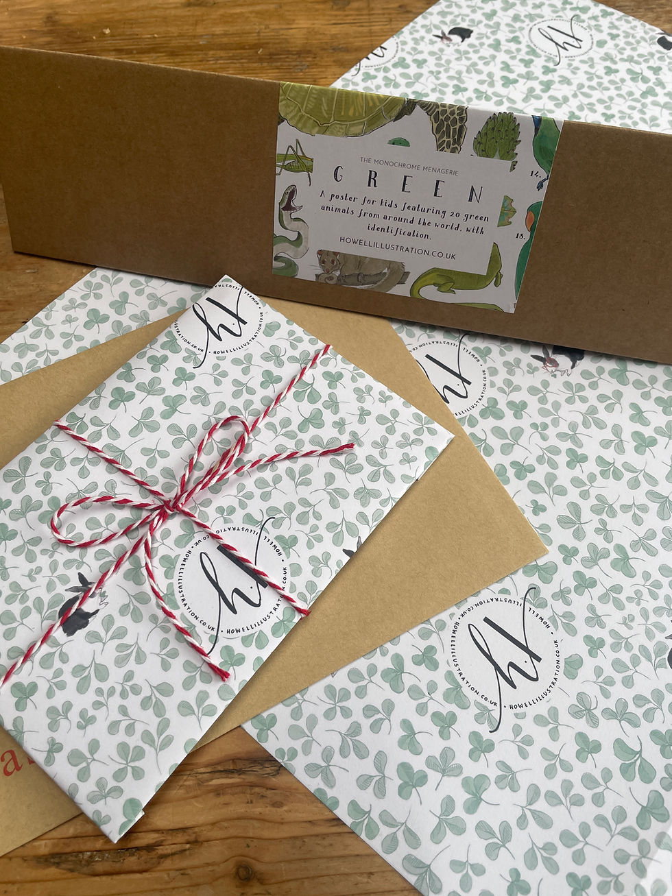 Illustrated wrapping paper featuring clovers, rabbit and a Howell Illustration graphic is wrapped around a greetings card and shown underneath one of my poster boxes