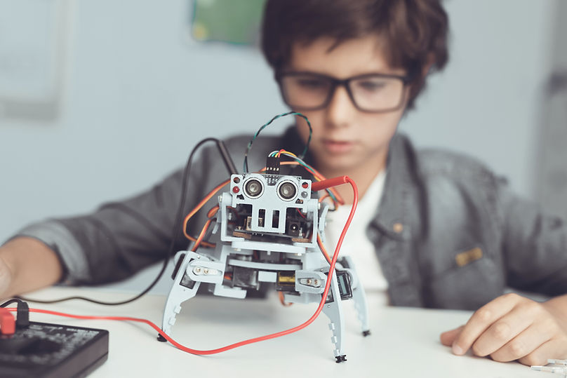 Focused student boy building a robot in class, demonstrating the impact of My Mindful Class mindfulness and SEL tools on student concentration, problem solving, and hands on learning.