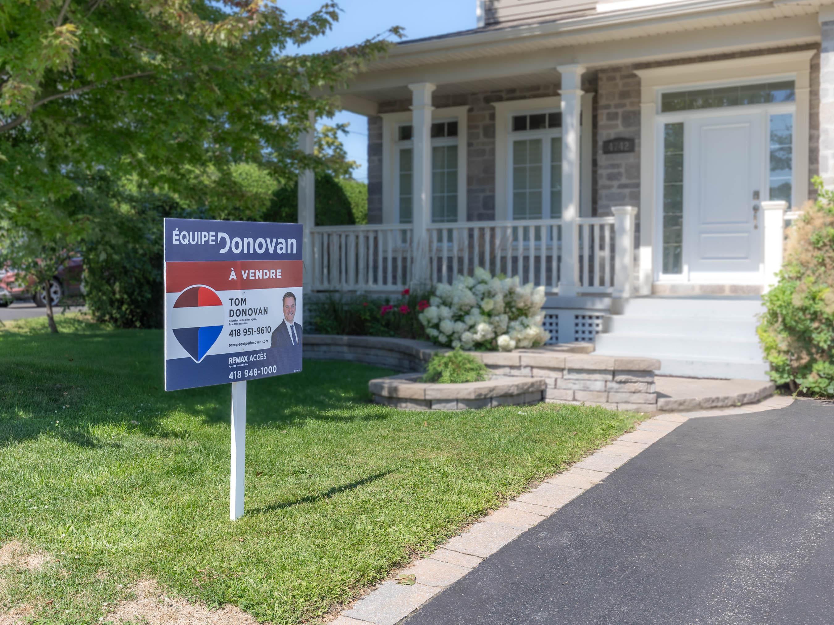 Pancarte immobilière À vendre devant une maison résidentielle