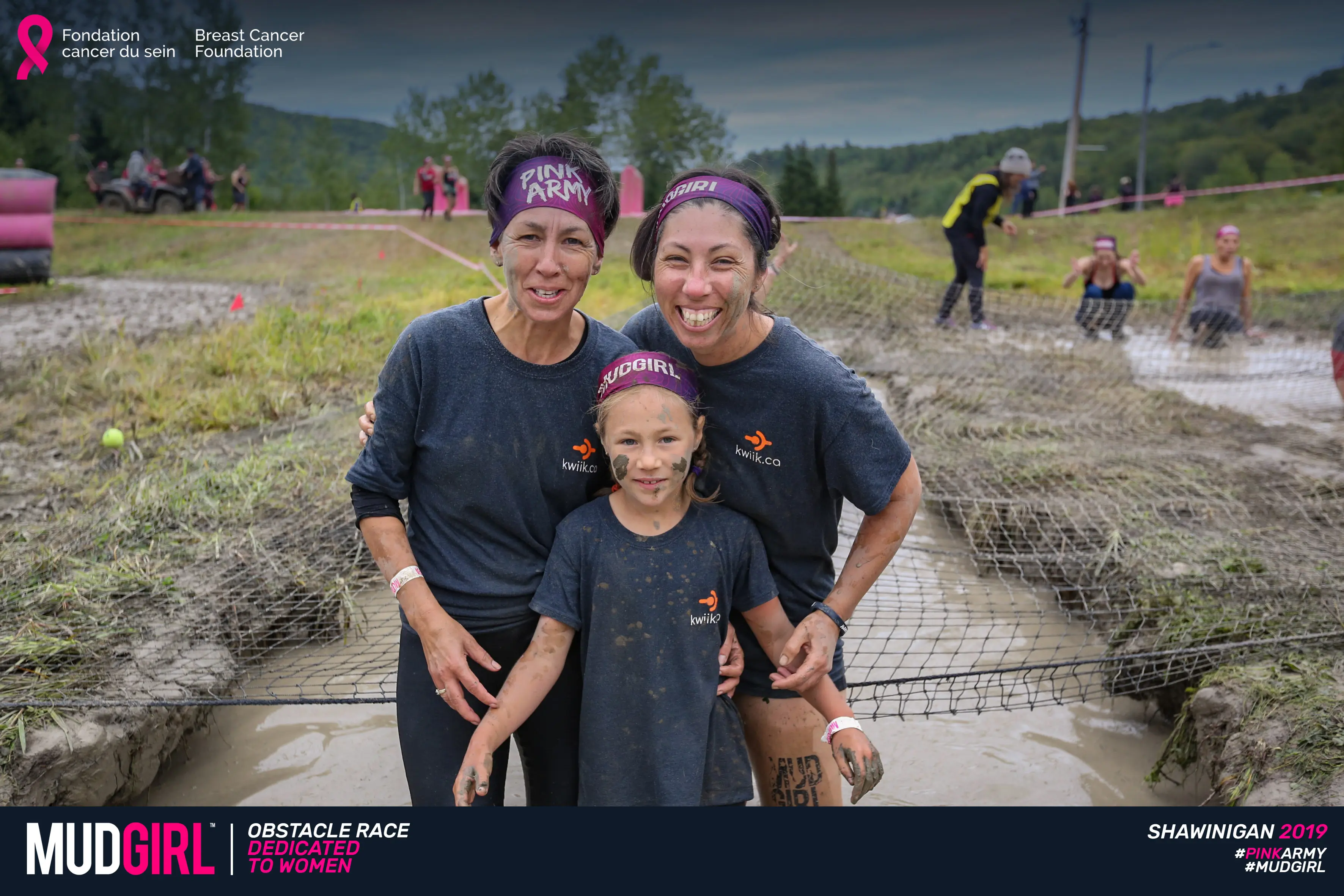 The smiling, mud-covered Kwiik team in front of a net obstacle at the MUDGIRL race