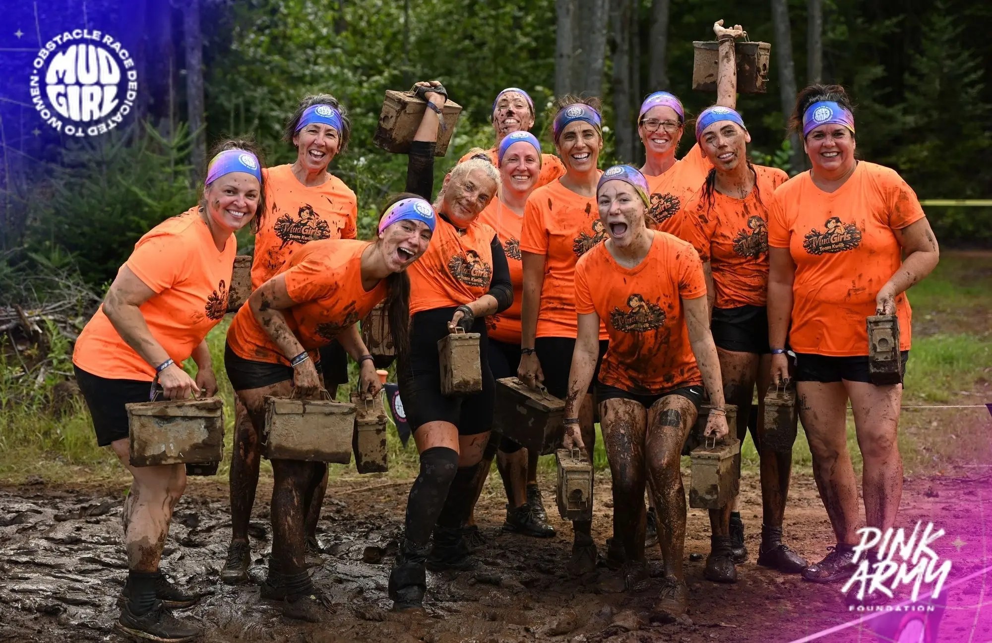 The muddy Kwiik team holding obstacle boxes at the MUDGIRL race