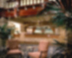 Reception area of hotel, blue floral rug, two pink and beige striped accent chairs