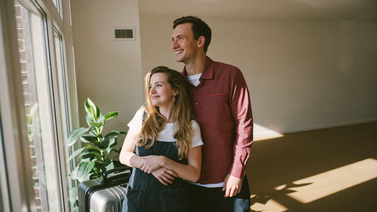 A young couple standing in their new apartment after an international move
