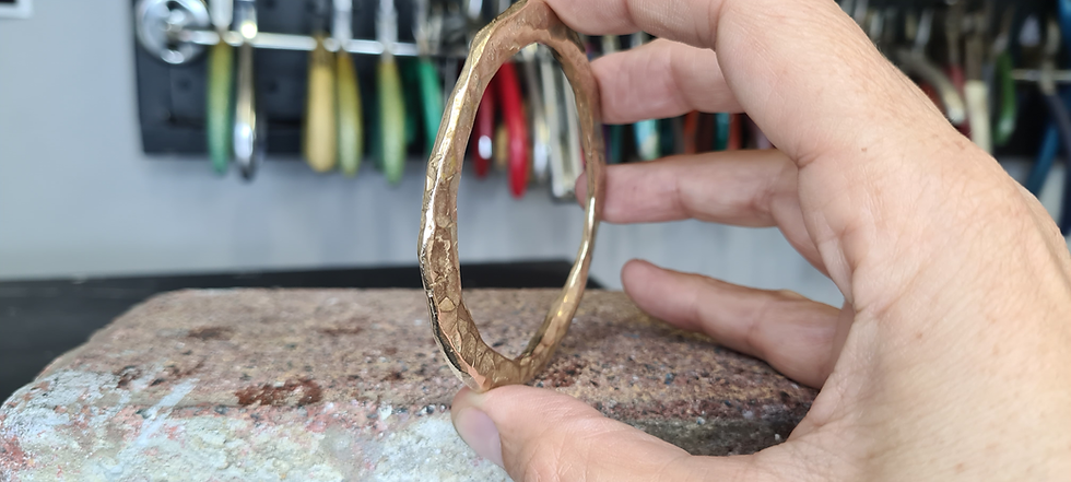 Thumbnail: Close-up of textured yellow bronze bracelet with tools in background