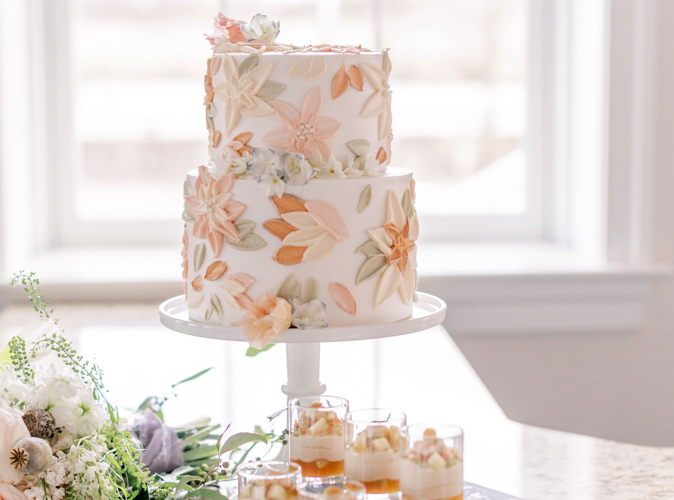 Buttercream wedding cake with palette knife flowers in neutral tones of peach, sage, and ivory