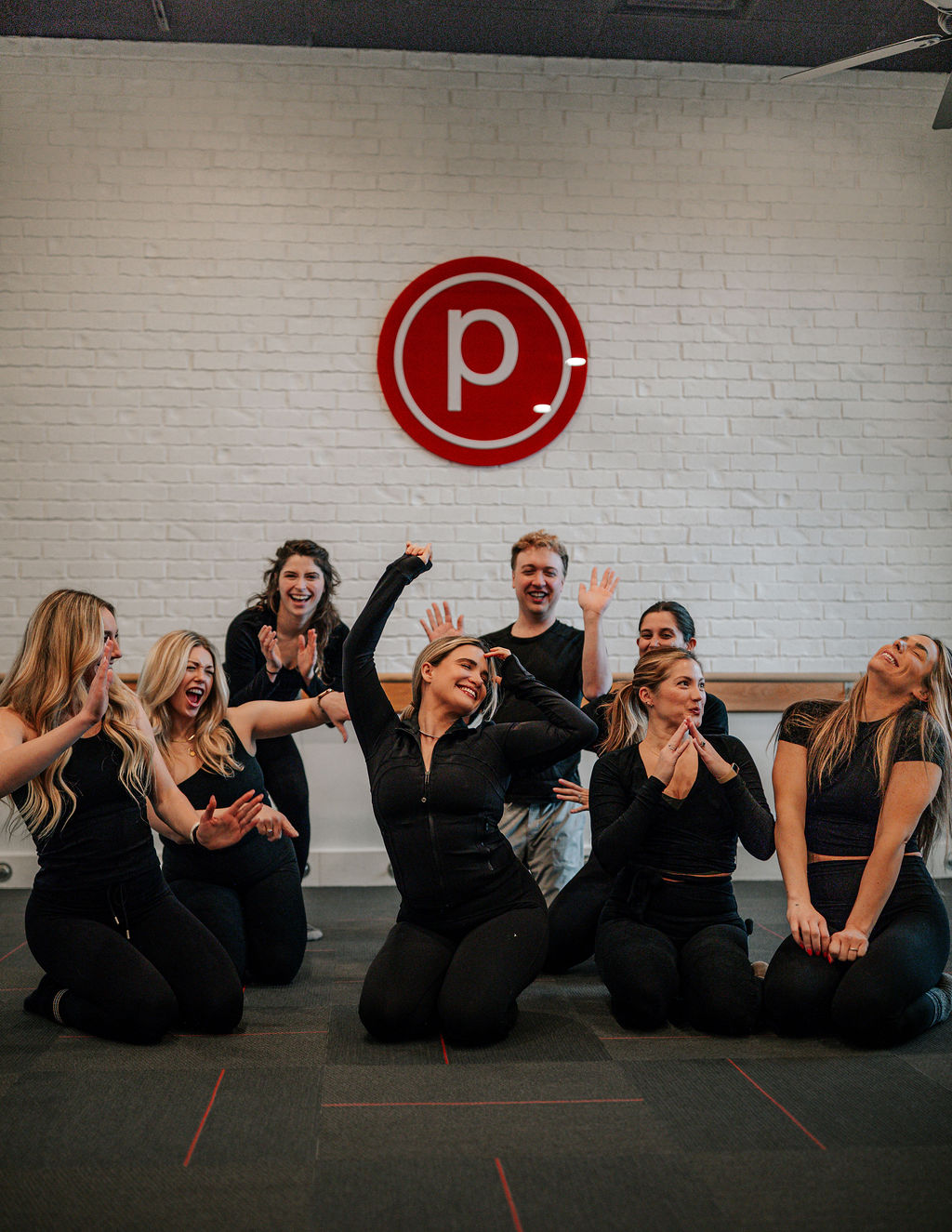 Pure Barre clients cheering together in the studio after class in Atlanta OTP.