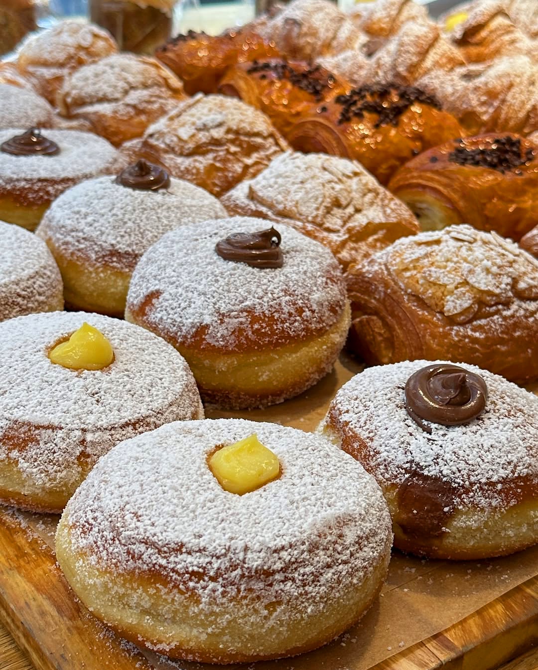 Powdered bombolone donuts filled with chocolate and custard.