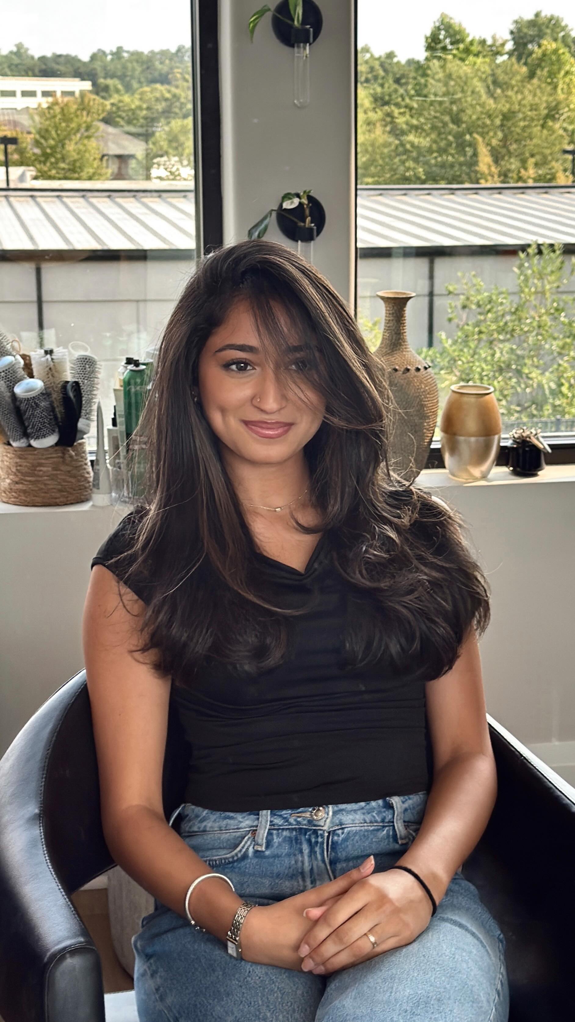 Client seated with shoulder-length dark hair and layered shape.