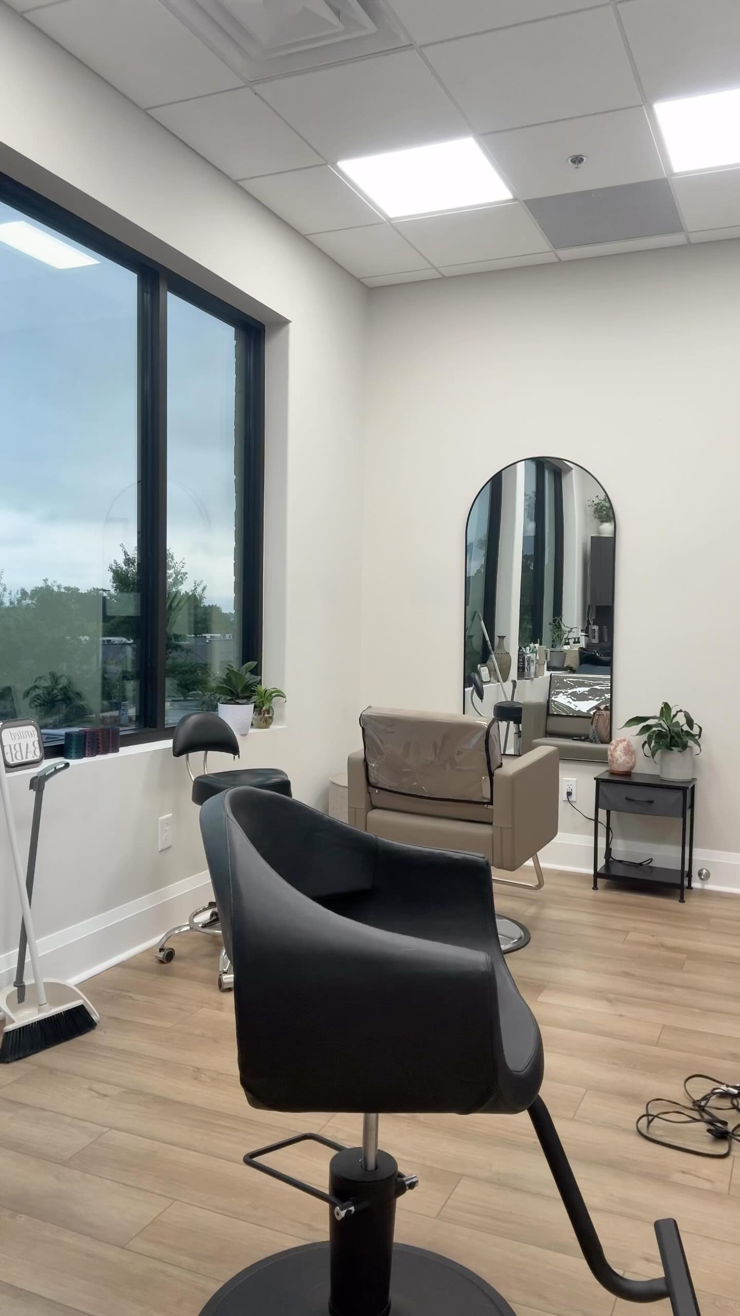 Salon chair and mirror set by a bright window inside the Alpharetta salon.
