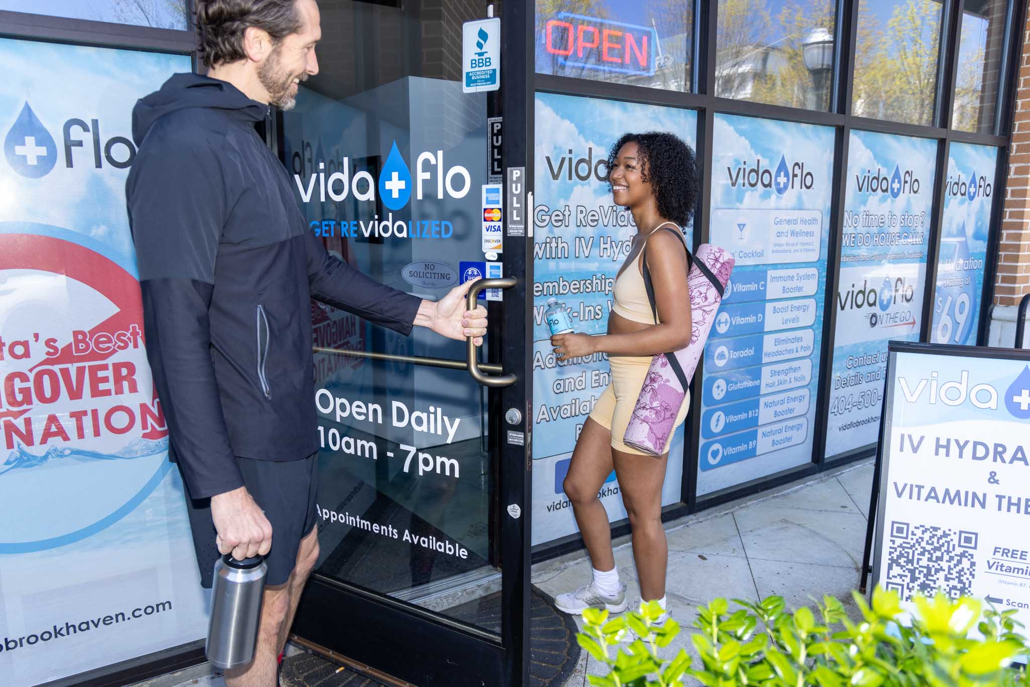 Man and woman enter glass front door of Vida-Flo Town Brookhaven Atlanta clinic.