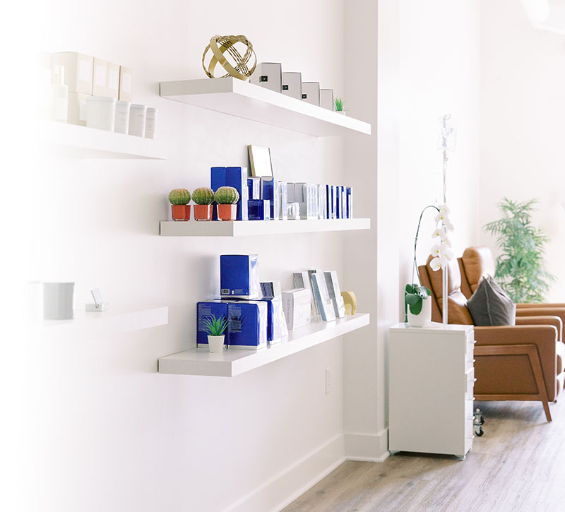 Sunlit lobby with sofa and shelving inside a Charlotte medical spa.