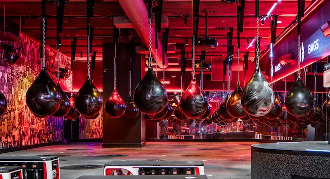 Row of hanging water punching bags under red lights, West Midtown Atlanta.
