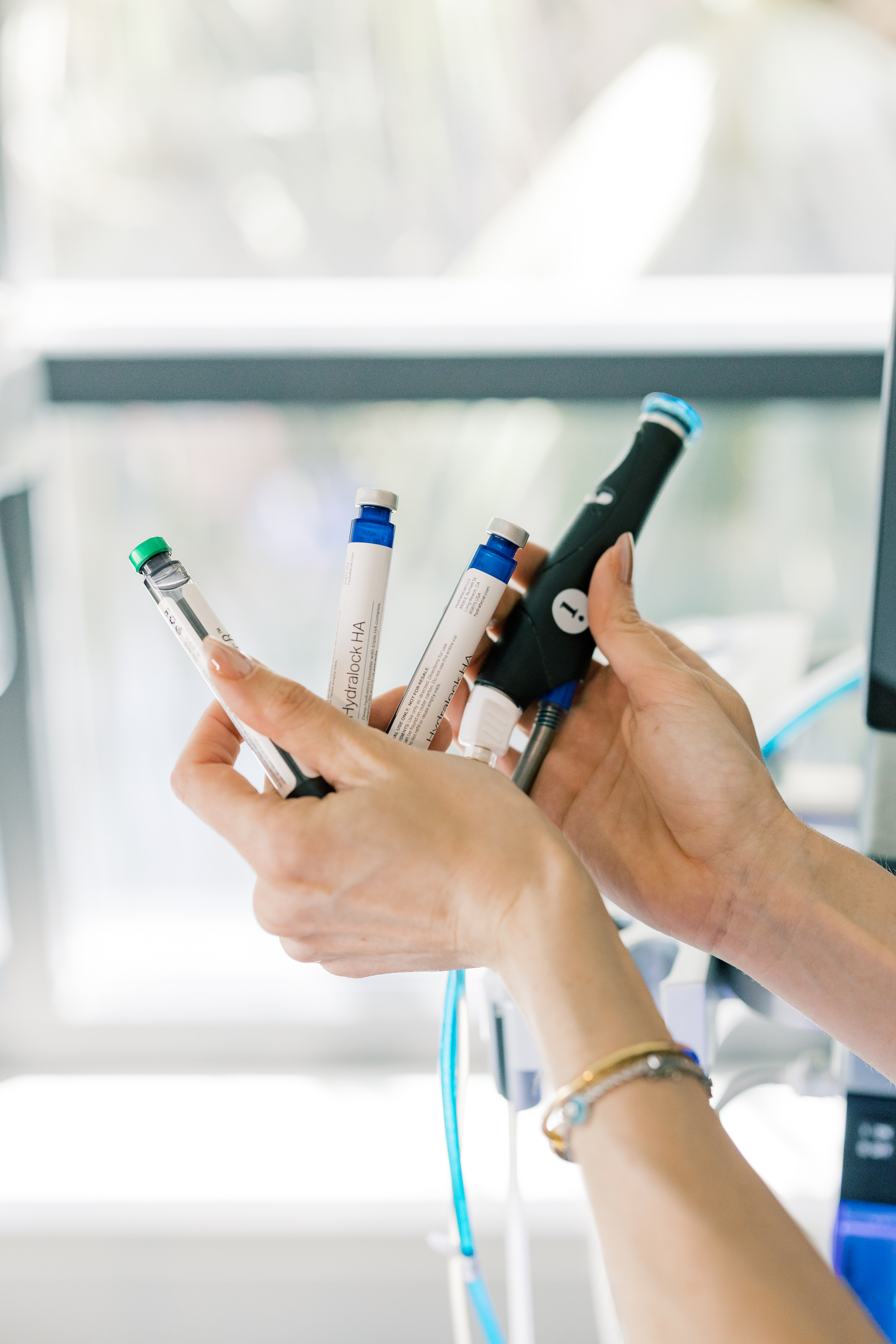 Close-up of hands holding medspa treatment tools at Pearl Medspa Charleston.