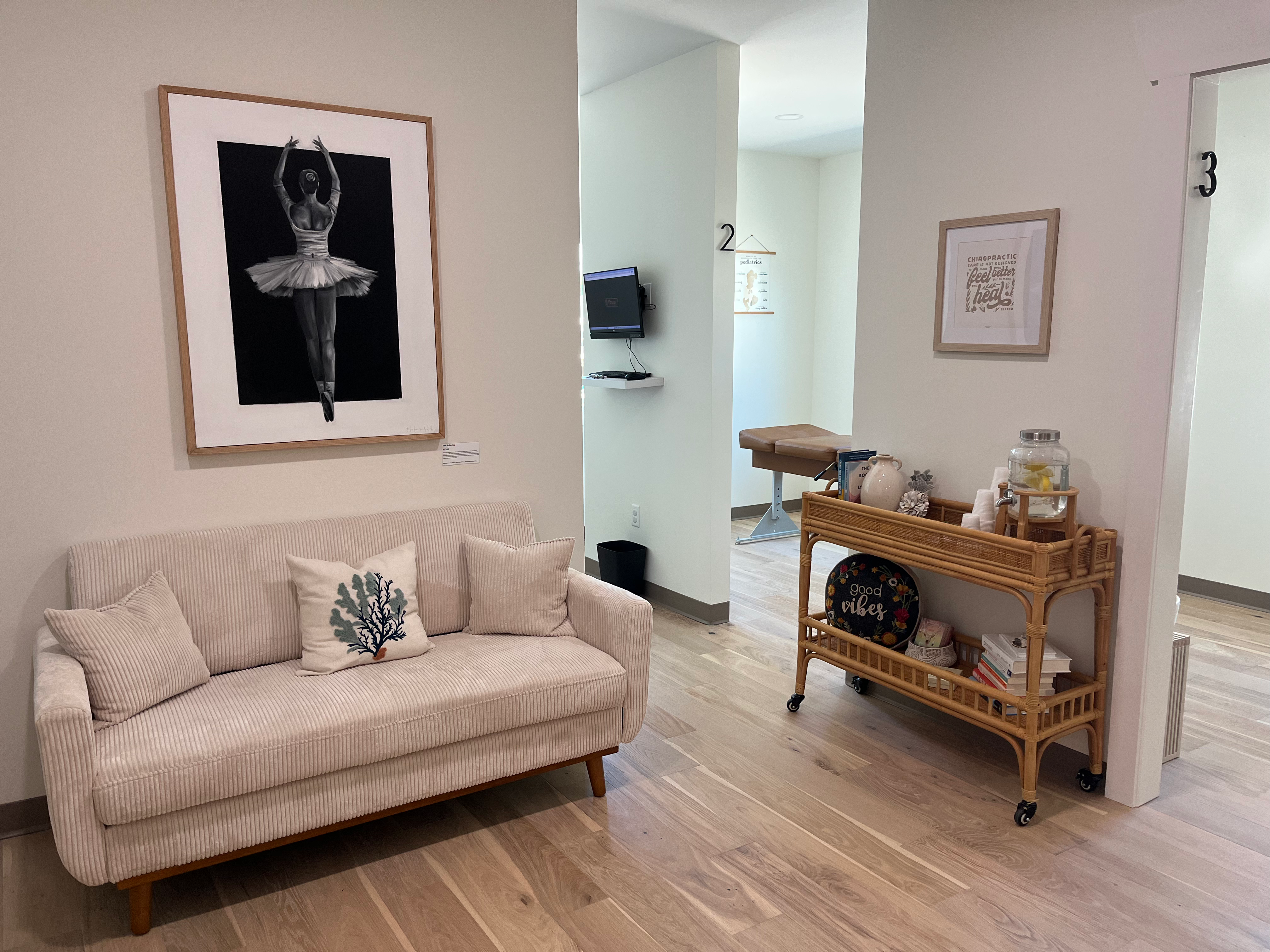 Reception lounge with couch, coffee table and spine artwork at Modern Chiropractic Johns Island Charleston