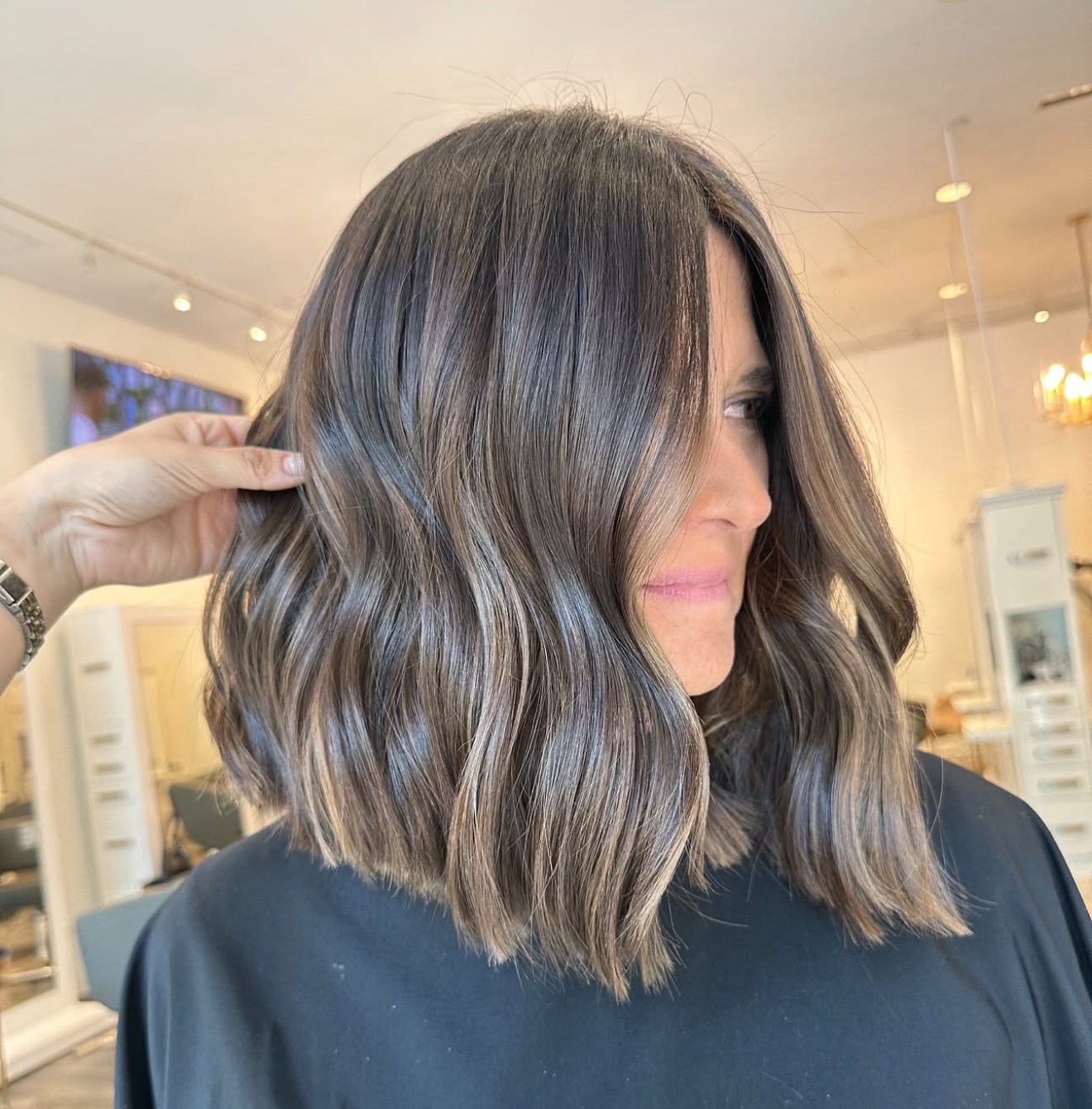 Textured shoulder-length brunette lob haircut inside J Gold Salon Atlanta.